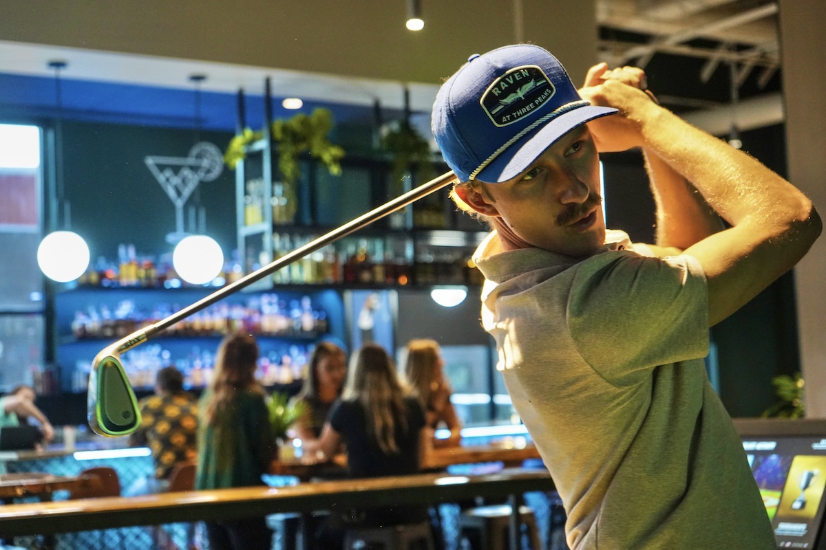 golfer with mustache playing golf indoors