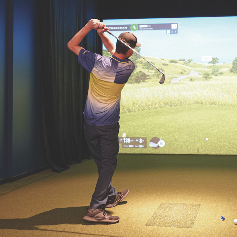 golfer swinging golf club indoor golf